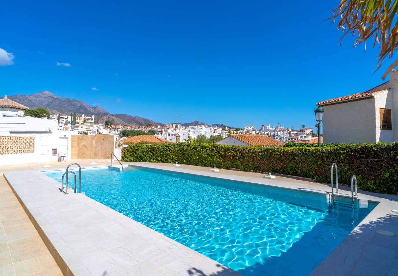 Piscine extérieure à l'eau cristalline à l'appartement Miami 44 Seaview Apartment à Nerja, parfait pour des vacances relaxantes.